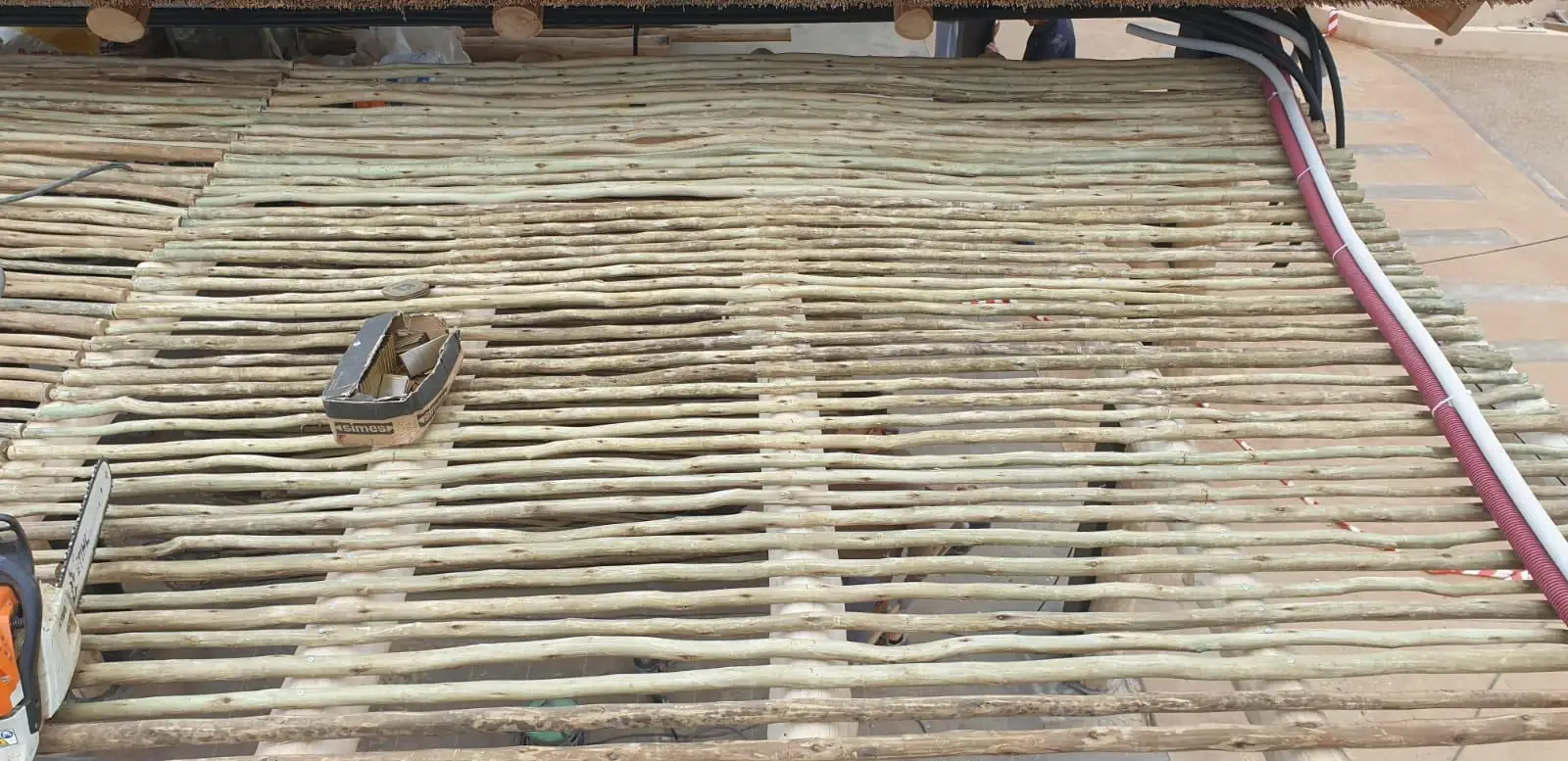 Reparto de varas de eucalipto durante el montaje de un techo